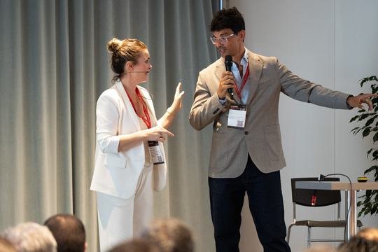 Sami hosting the Demo Stage, on stage with a speaker