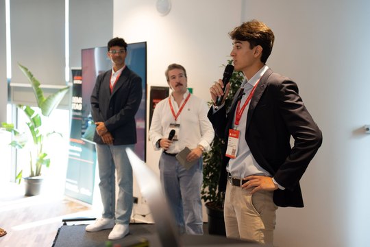 Three speakers on the Demo Stage at AI Summit Barcelona 2026, one taking the microphone